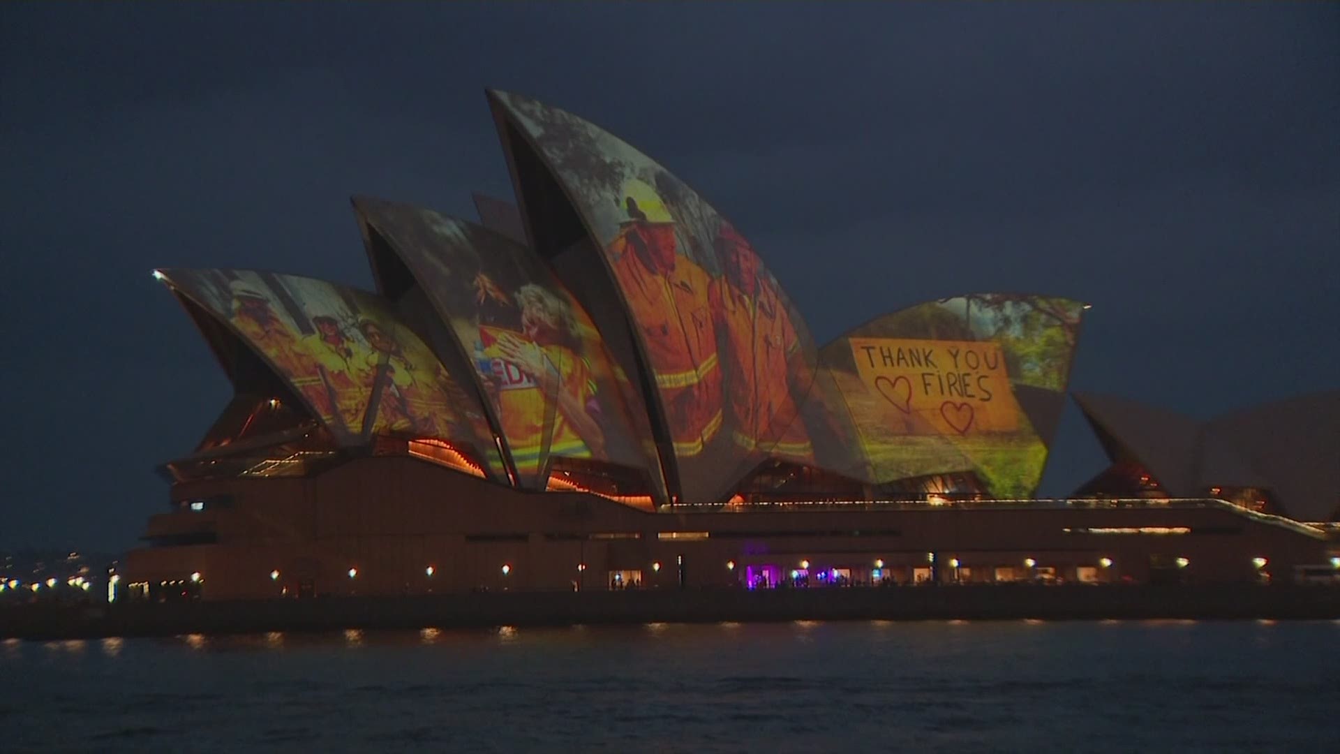 The sails of the iconic Sydney Opera House were illuminated on Saturday to show support for firefighters and wildfires-affected communities. (CHANNEL 7 via AP)