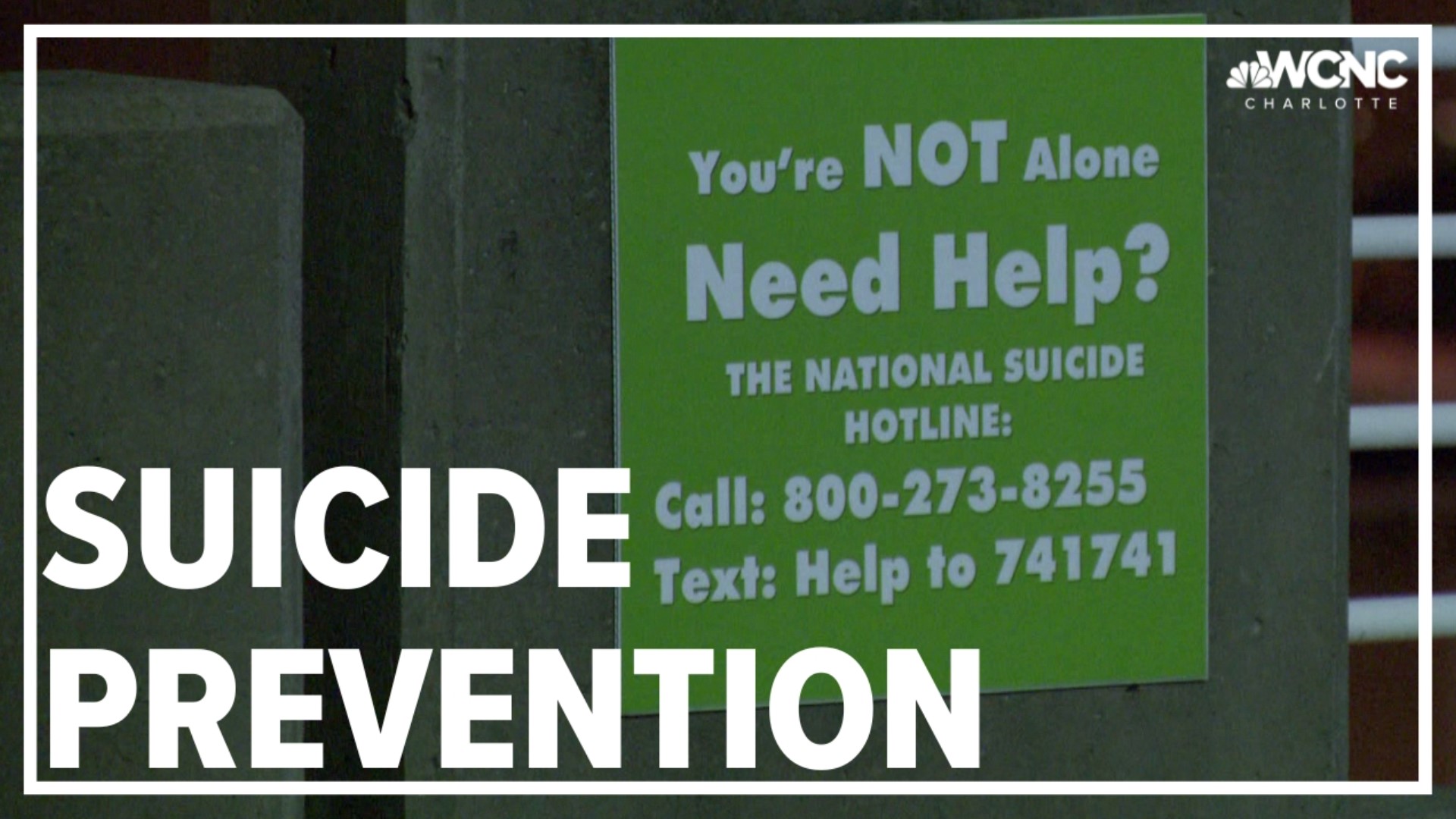 Green signs with the suicide prevention hotline phone number have been placed in parking decks across the Queen City.