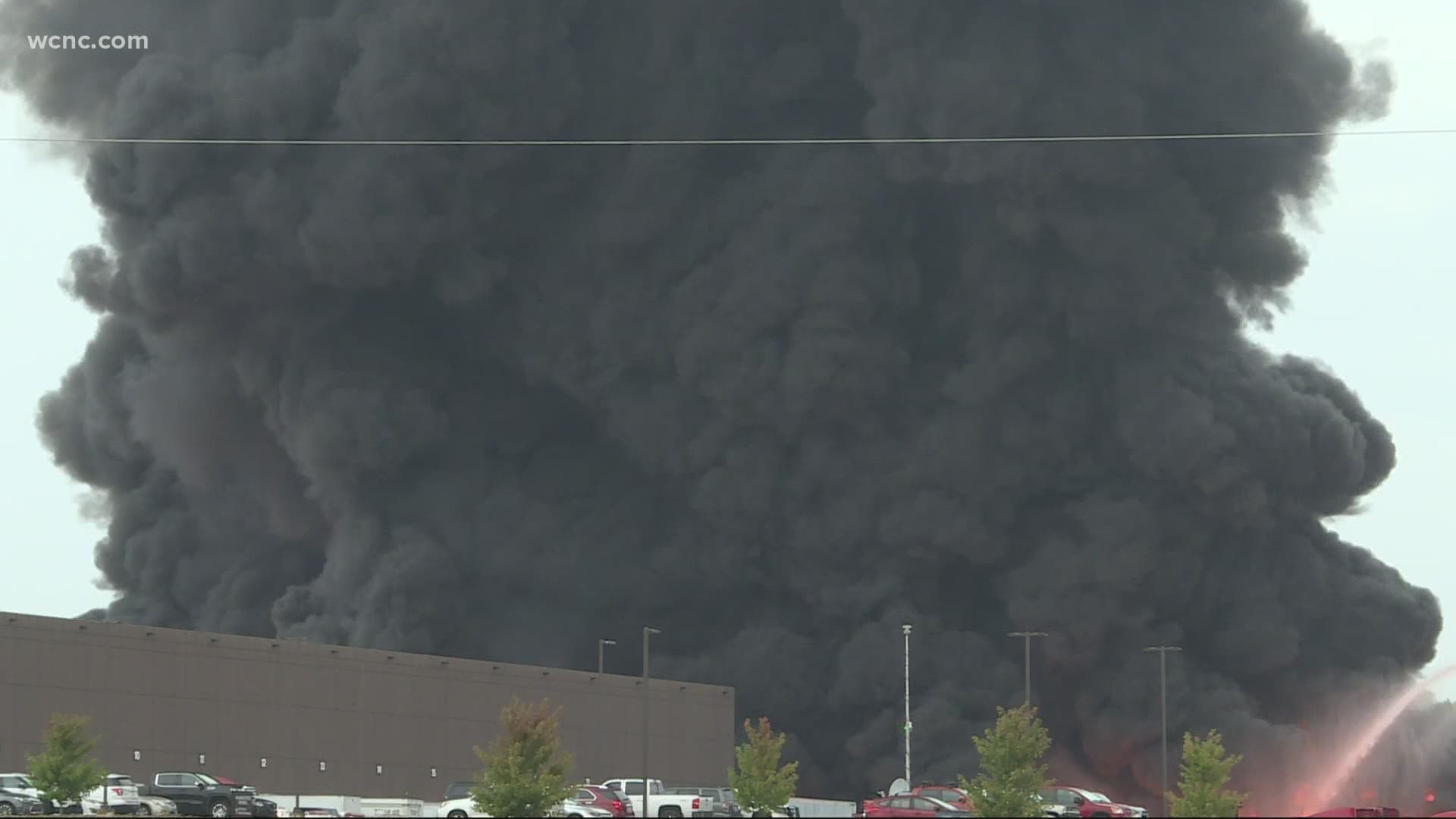 A huge smoke plume can be seen from miles away as firefighters work to continue the industrial fire.