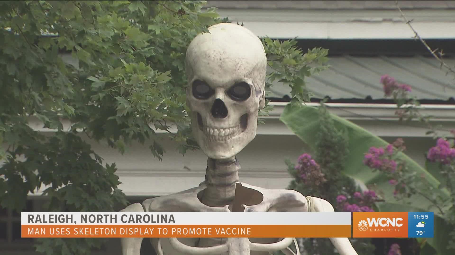 A Raleigh is using a skeleton display to encourage neighbors to get the COVID-19 vaccine.
