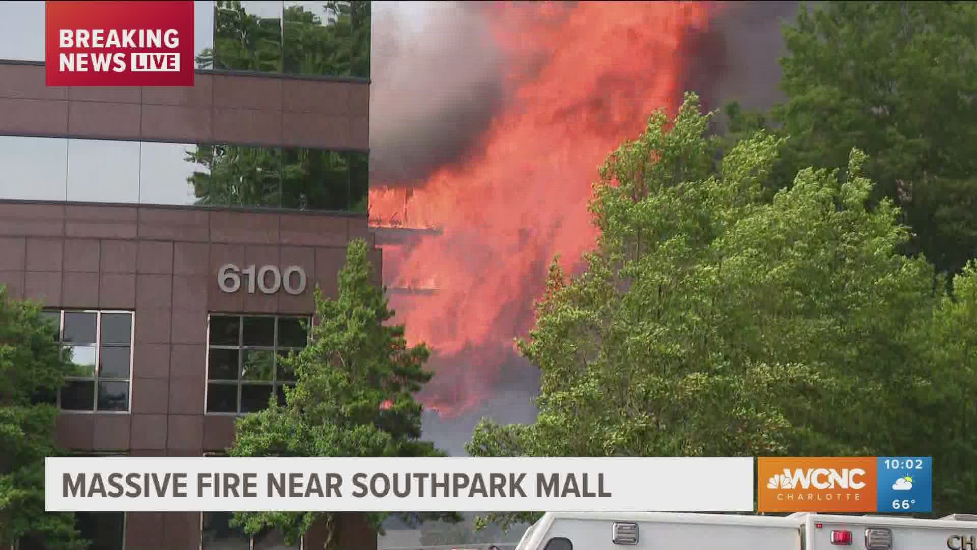 Flames from a massive 5-alarm fire burning in south Charlotte are seen shooting up into the sky.