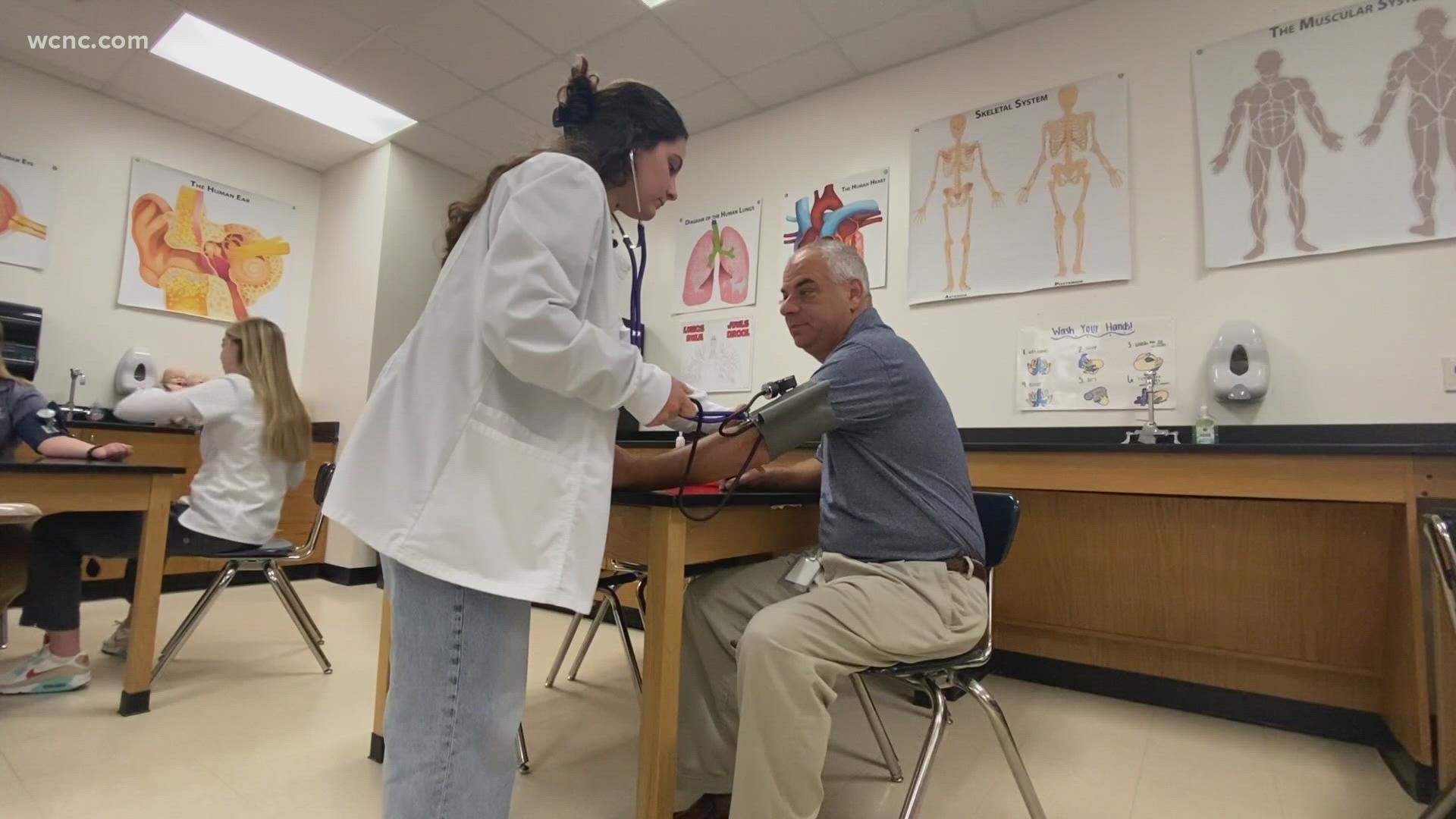 Twice a week, real patients come through the doors of an immersive classroom at Cuthbertson High School. Students are tasked with doing health care screenings.