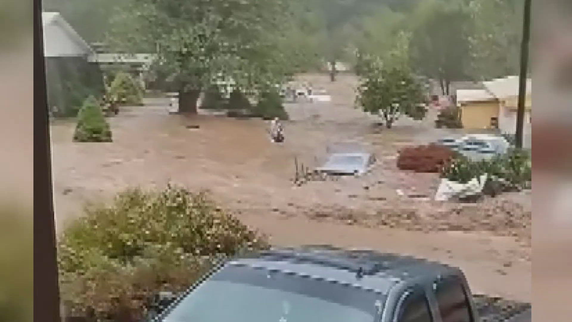 Cellphone video shows a man walking through chest-deep water to rescue a neighbor who was trapped as floodwaters overtook Avery County.