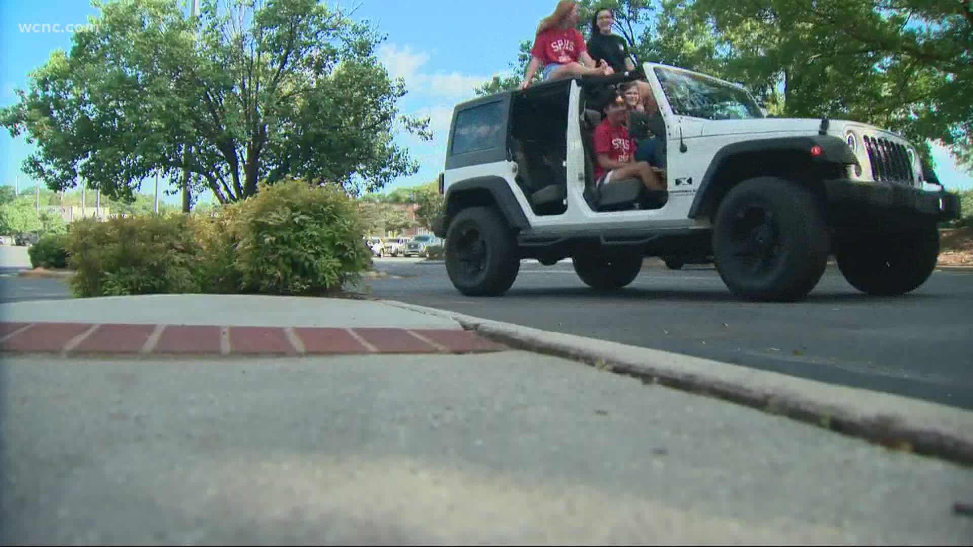 Students at South Pointe High School wore their caps and gowns as they drove around the school parking lot.