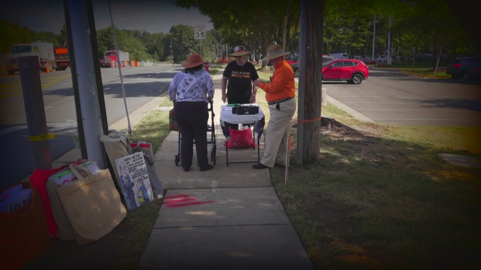 Striking to see, is just who holds the protest signs. They are mostly senior citizens. A few are crossing the street using walkers.