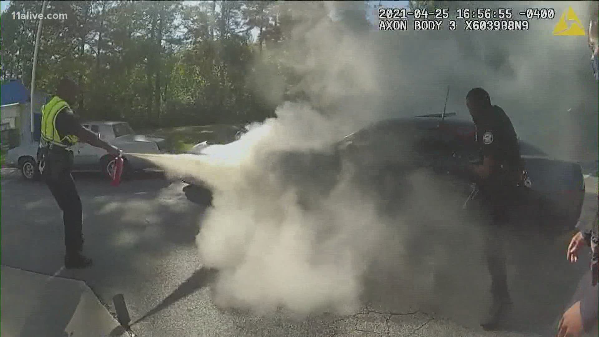 Police released a video showing the heroic moment officers break into a smoking car to save the driver